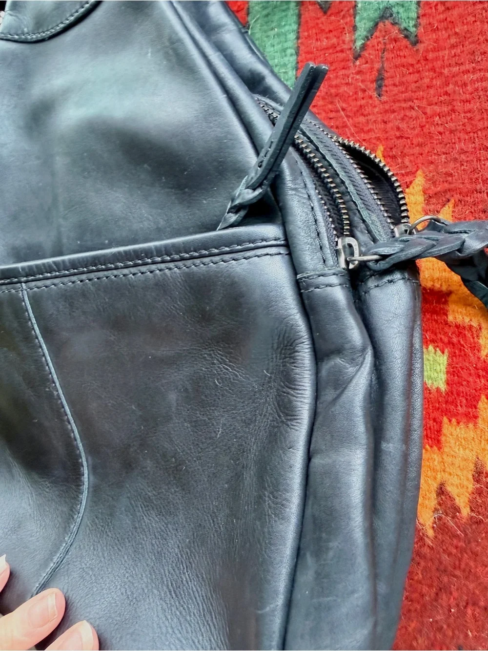 Black trianglular leather backpack with multiple pockets